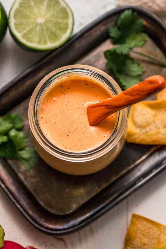 Overhead shot of southwest ranch in small jar with wooden spoon. 